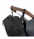 Mochila negra rectangular GRE Cross Lässig acoplada al manillar marrón de un carrito de bebé con correas resistentes.