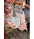 Mochila Slender Lässig rosa pálido abierta y colgada de un carrito, con interior gris y varios bolsillos organizadores.
