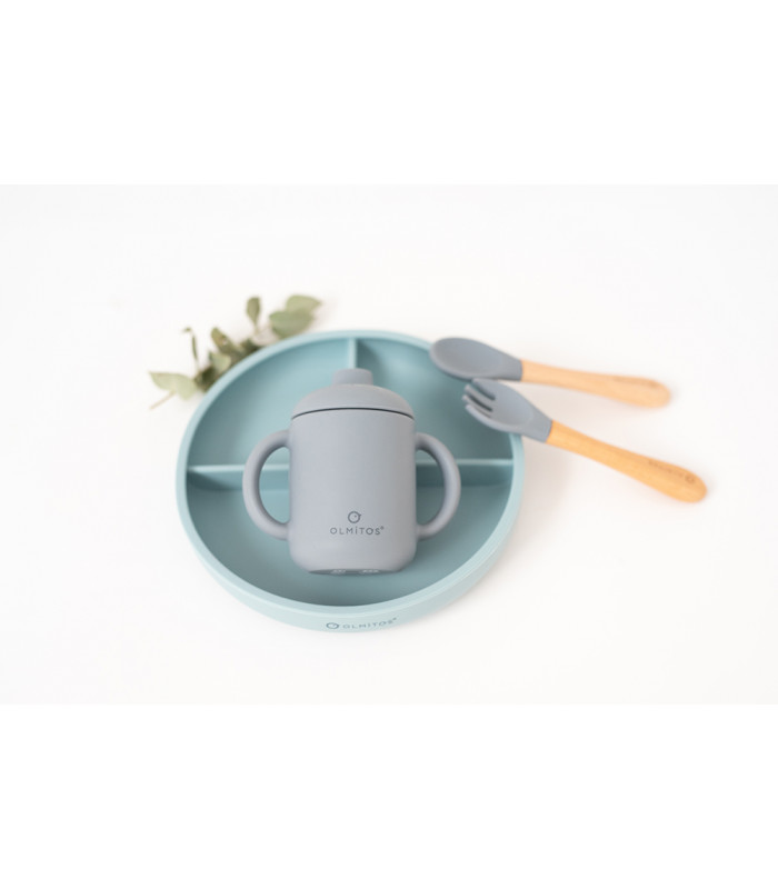 Vajilla infantil Olmitos de silicona azul con plato dividido, taza con boquilla y cubiertos con mango de madera.