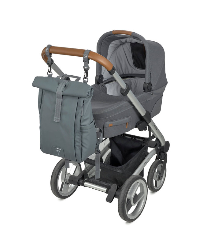 Mochila Lässig gris de diseño rolltop fabricada en tela, colgada de un carrito de bebé gris con manillar marrón.