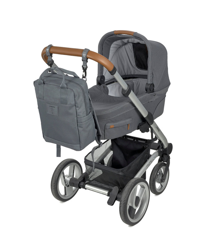 Mochila para pañales Lässig gris de tela resistente, colgada del manillar marrón de un carrito de bebé gris y plateado.