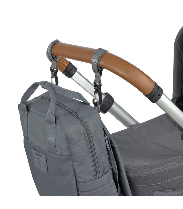 Mochila de pañales Vividal Lässig gris de tela, colgada con correas al manillar marrón de un carrito de bebé.