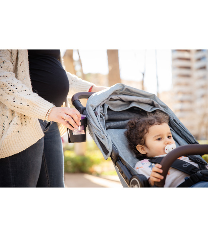 Silla de paseo VentT+ Niu azul claro con detalles marrones, usada por una mujer con un niño sentado en el exterior.