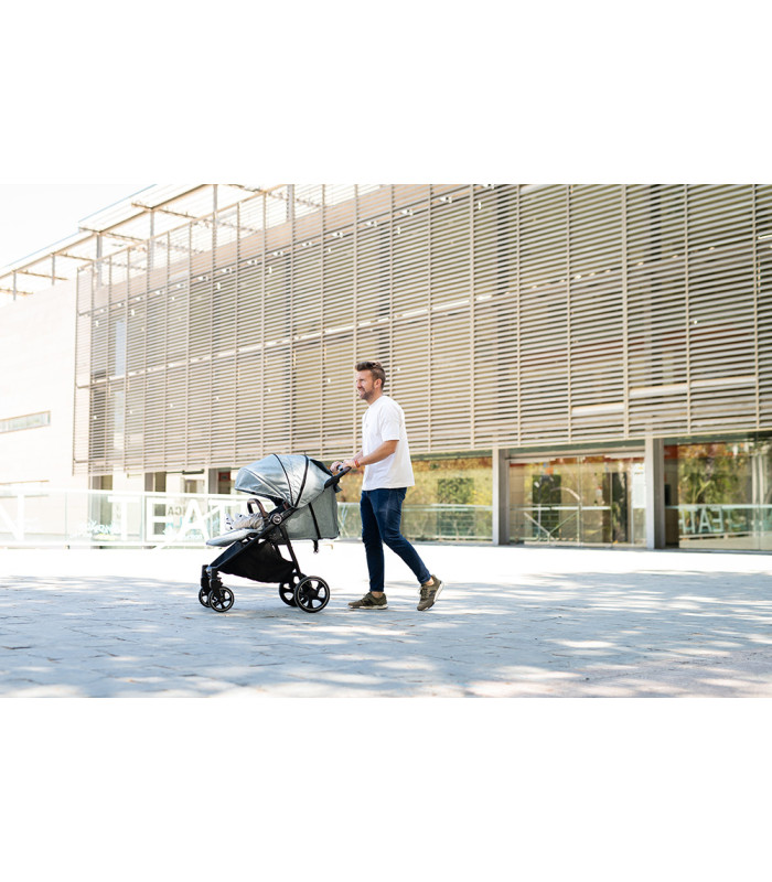 Silla de paseo VentT+ Niu gris con chasis negro y capota amplia, manejada por un hombre en un entorno exterior.