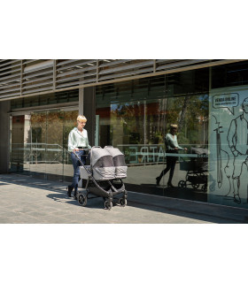 Capazo gemelar VentTwin+ Niu en color gris con chasis negro, diseñado para pasear cómodamente a dos bebés.