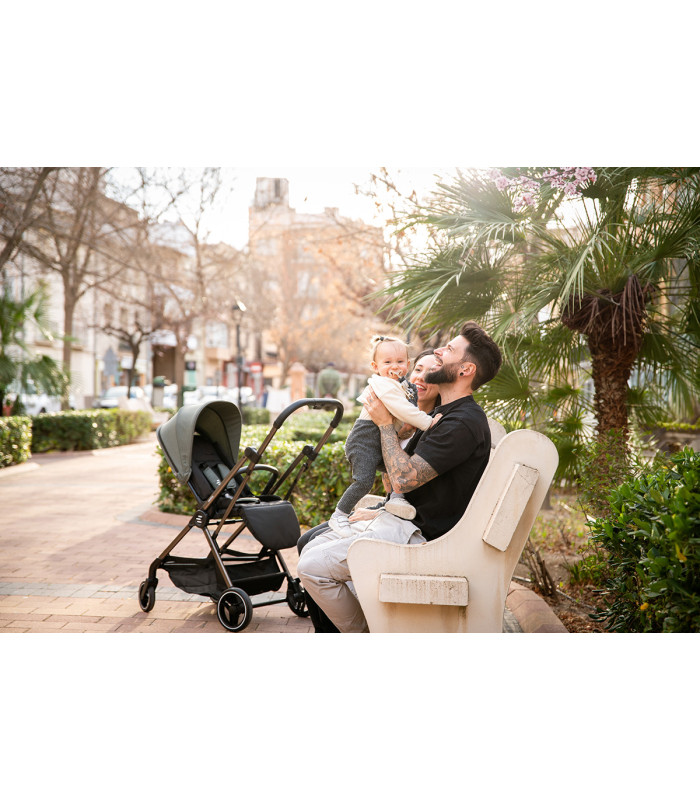 Silla de paseo Eolia Niu gris oscuro con chasis negro y diseño compacto, ideal para paseos urbanos en el parque.